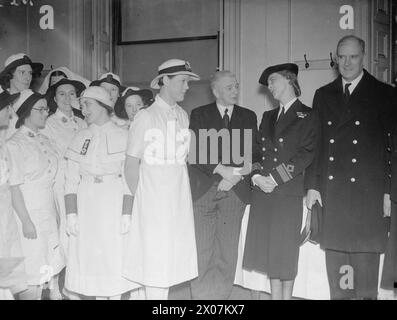 WRENS EN ROUTE POUR SINGAPOUR. 1941. SAR LA DUCHESSE DE KENT, COMMANDANT DU WRNS, ET LE PREMIER LORD DE L'AMIRAUTÉ ONT RENDU VISITE AU GROUPE DES WRENS QUI ONT ÉTÉ SÉLECTIONNÉS POUR SERVIR À SINGAPOUR. - SAR la duchesse de Kent et M. A. V Alexandre discutant lors de leur visite aux Wrens. Sur la gauche de M. Alexander se trouve le second officier H E Archdale, WRNS, qui est en charge du parti des Wrens en route pour Singapour Archdale, Helen Elizabeth, Alexander, Albert Victor, Marina, princesse (duchesse de Kent), Royal Navy, Women's Royal Naval Service Banque D'Images