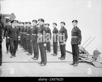 AVEC LE PORTE-FLOTTES LÉGER HMS VENGEANCE. MARS ET AVRIL 1945, EN MÉDITERRANÉE. ACTIVITÉS DES AVIATEURS ET DES NAVIRES JUMEAUX EN MÉDITERRANÉE. - Le contre-amiral C. H. J. Harcourt, CB, CBE, inspectant les Royal Marines à bord de la VENGEANCE Banque D'Images