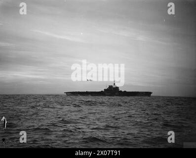 À BORD DU DESTROYER HMS ESKIMO. 1942, PENDANT LES OPÉRATIONS DE LA FLOTTE LOCALE. - Avion tournant autour du porte-avions VICTORIEUX avant l'atterrissage Banque D'Images