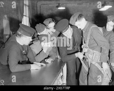 BRITISH AIRCRAFT TRAINING CORPS. LES GARÇONS VISITENT UNE STATION AÉRIENNE DE LA ROYAL NAVY 18 JANVIER 1942, STATION AÉRIENNE DE LA ROYAL NAVY DONIBRISTLE. CHAQUE DIMANCHE, LORSQUE LES CIRCONSTANCES LE PERMETTENT, LES GARÇONS DE L'ATC DES VILLES VOISINES VISITENT LA ROYAL NAVY AIR STATION. - Un grand frisson, un jeune garçon ATC a un parachute monté et on lui montre comment utiliser le cordon de sécurité en cas d'urgence Banque D'Images