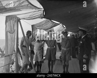 LE CROISEUR BRITANNIQUE HMS AJAX VISITE LA TURQUIE. DU 15 AU 18 SEPTEMBRE 1945, À BORD DU HMS AJAX, ET À TERRE À ISTANBUL. LORS DE LA VISITE DU HMS AJAX ET DES DESTROYERS HMS MARNE ET HMS METEOR À ISTANBUL. À BORD DU CROISEUR SE TROUVAIENT S.A.R. EMIR ABDUL ILLAH, RÉGENT DE L'IRAK, ET SON PERSONNEL. LE 16 SEPTEMBRE 1945, LE CAPITAINE J CUTHBERT, RN, DE L'AJAX DÉPOSE UNE COURONNE SUR LE MÉMORIAL DE L'INDÉPENDANCE TURQUE SUR LA PLACE TAKSIM, ISTANBUL, ET LE LENDEMAIN, LE CROISEUR EST OUVERT AUX VISITEURS. - Lady Peterson, épouse de Sir Maurice Peterson, ambassadeur britannique en Turquie, arrivant à bord de l'AJAX pour un cocktail. Elle est reçue b Banque D'Images