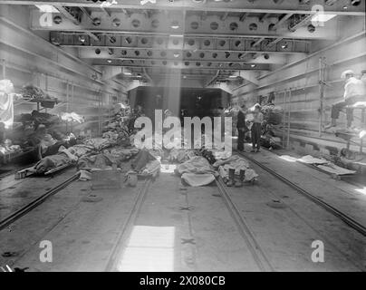 AVEC UN NAVIRE DE DÉBARQUEMENT DE CHAR D'HÔPITAL. LES 10 ET 11 AOÛT 1944, COURSSELLES, FRANCE, AVEC LST 428. SPÉCIALEMENT AMÉNAGÉ POUR CETTE TÂCHE, LE LST 428 AIDE À TRANSPORTER LES VICTIMES, Y COMPRIS LES BLESSÉS ENNEMIS, DE LA ZONE DE BATAILLE AU ROYAUME-UNI. - Vue générale à bord du LST avec des Allemands blessés allongés sur le pont au premier plan Banque D'Images