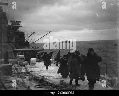 CONVOI EN RUSSIE, AVEC ESCORTE DE CROISEUR BRITANNIQUE SUR LA LIGNE DE VIE ARCTIQUE. DÉCEMBRE 1941, À BORD DU CROISEUR HMS SHEFFIELD. - Scène occupée sur la neige couverte fo`c'sle comme torpillage se préparer à `sortir des paravanes' Banque D'Images