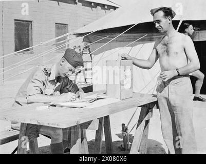 FORCE AÉRIENNE ROYALE AU MOYEN-ORIENT, 1944-1945. - L'aviateur McLeash de Musselburgh, en Écosse, servant dans un escadron de la RAF en Afrique du Nord, dépose son papier dans les urnes devant un chapiteau de scrutin, lors du vote pour les élections générales de 1945 Banque D'Images