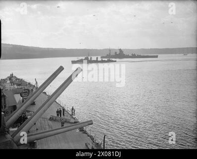 DÉMINAGE. OCTOBRE 1940, À BORD DU CUIRASSÉ HMS RODNEY. CHAQUE FOIS QUE DES AVIONS ENNEMIS AVAIENT ÉTÉ DANS LE VOISINAGE DU MOUILLAGE DE LA FLOTTE PENDANT LA NUIT, IL EST ASSEZ CERTAIN QUE DES MINES ONT ÉTÉ POSÉES ET LES DRAGUEURS DE MINES ONT BEAUCOUP DE TRAVAIL. - Le destroyer HMS BEAGLE passant entre le NELSON et le RODNEY à l'ancre à 20 nœuds dans une tentative de localiser une mine acoustique avec la vibration de ses moteurs Banque D'Images