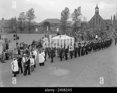 PÈLERINAGE NAVAL CATHOLIQUE À LOURDES ÉCOSSAISE. 2 SEPTEMBRE 1944, CARFIN, ÉCOSSE. LE PÈRE JOHN WILSON, AUMÔNIER NAVAL, DIRIGEA PLUS D'UNE CENTAINE D'OFFICIERS DE MARINE CATHOLIQUES, DE MATELOTS ET DE WRNS DE NAVIRES ET D'ÉTABLISSEMENTS DE HM DANS L'EST DE L'ÉCOSSE LORS D'UN PÈLERINAGE AUX LOURDES ÉCOSSAIS À CARFIN. LES OFFICIERS ET LES OFFICIERS PORTAIENT LA CANOPÉE DU SACREMENT BÉNI, TENUE PAR LE PÈRE W TINDALL-ATKINSON EN PROCESSION À LA GROTTE, ET DEVANT LE SANCTUAIRE DE NOTRE DAME, IL DONNA LA BÉNÉDICTION, ET ENFIN BÉNIT LA CONGRÉGATION DE 2 000 PERSONNES. - La procession à l'église Carfin, près du sanctuaire de notre-Dame Banque D'Images