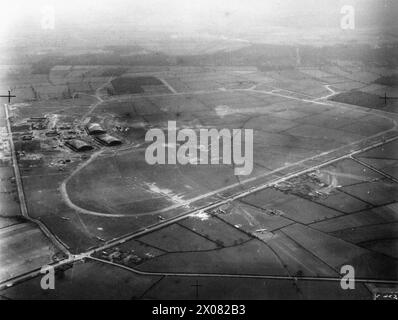 COMMANDEMENT DES BOMBARDIERS DE LA ROYAL AIR FORCE, 1939-1941. - Vue aérienne oblique de RAF Swinderby, Lincolnshire, vue sud-sud-ouest. Vickers Wellingtons appartenant aux Nos 300 et 301 Polish Bomber Squadrons RAF peuvent être vus stationnés sur l'aérodrome et sur les casseroles circulaires de deux dispersions à trois impulsions construites à travers la fosse Way (A46) au premier plan. Sur la gauche, une route publique court vers l'est à partir des maisons de transition (en bas à gauche) à Lane Moor Lane, divisant le site technique de l'aérodrome et les hangars du site domestique (à gauche) Royal Air Force, 1 unité de camouflage, Force aérienne polonaise, Force aérienne polonaise, 3 Banque D'Images