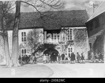 COLONIE POUR ARTISTES DE MOINS DE SIX ANS : ÉVACUÉS À DARTINGTON HALL, TOTNES, DEVON, ANGLETERRE, 1941. - Les enfants évacués à Dartington Hall dans le Devon retournent à leur billet après une promenade dans la campagne. Derrière les enfants, une partie de la Grande salle du XIVe siècle à Dartington peut être vue. La salle et d'autres parties du domaine médiéval ont été réparées et reconstruites par Leonard et Dorothy Elmhirst dans les années 1920 Banque D'Images