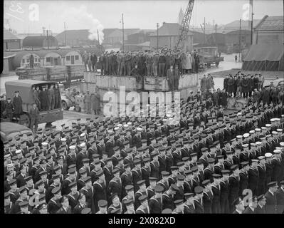 LES FRÉGATES D'ESCORTE OBTIENNENT DEUX U-BOOTS DE PLUS. 30 MARS 1944, BELFAST. LES FRÉGATES DU 1ER GROUPE D'ESCORTE, LE HMS AFFLECK, ET SES NAVIRES JUMEAUX GORE, GOULD ET GARLIES DÉTRUISENT DEUX SOUS-MARINS DANS L'ATLANTIQUE. PHOTOS DE RETOUR DU GROUPE. - Les compagnies de navires du premier Groupe d'escorte écoutant le premier ministre parler depuis le pont du HMS AFFLECK Banque D'Images