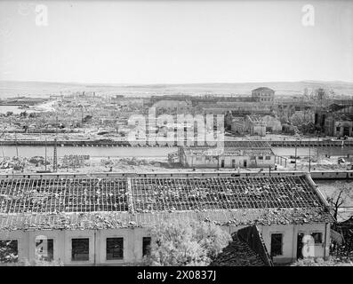 COMMENT LES FORCES AÉRIENNES ALLIÉES ONT MITRAILLÉ FERRYVILLE. 13 MAI 1943, FERRYVILLE, CHANTIER NAVAL FRANÇAIS, PRÈS DE BIZERTE. LE PORT DE FERRYVILLE A OBTENU SA PART DU BLITZ ALLIÉ PRESQUE SANS ESCALE SUR LES POINTS D’APPROVISIONNEMENT DE L’AXE QUI ONT PRÉCÉDÉ LA DÉFAITE TOTALE DE L’ALLEMAGNE ET DE L’ITALIE EN AFRIQUE. - Rejoindre Ferryville, montrant les dégâts causés par les raids aériens alliés. Sur la gauche de l'image, juste à côté de la jetée, se trouvent les restes d'un navire de munitions italien de 6 000 à 8 000 tonnes qui a reçu un coup direct d'une bombe. L'explosion a causé d'importants dommages au chantier naval, et des parties du navire ont été ramassées pas moins de Banque D'Images