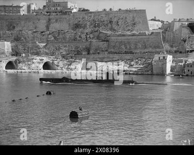 « VIE SOUS-MARINE » : TÂCHES DE DERNIÈRE MINUTE DEVANT UNE PATROUILLE MÉDITERRANÉENNE. MARS ET AVRIL 1943, MALTE, OFFICIERS ET HOMMES D'UN SOUS-MARIN BRITANNIQUE AVANT DE PARTIR EN PATROUILLE EN MÉDITERRANÉE. - Le début d'une patrouille offensive contre les navires de l'axe. Le sous-marin britannique P 51 quitte Malte Banque D'Images