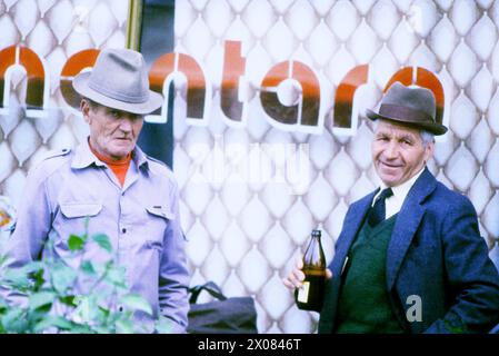 République socialiste de Roumanie, approx. 1979. Les villageois buvant un verre après le travail. Banque D'Images