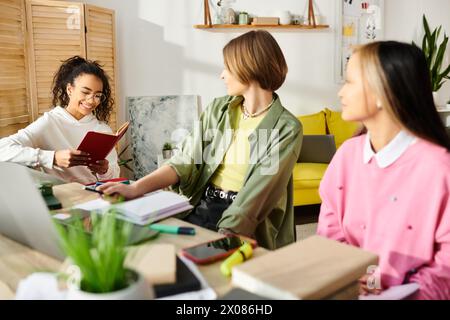 Un groupe diversifié de femmes, y compris des adolescentes interraciales, sont rassemblées autour d'une table, engagées dans l'étude et la promotion de l'amitié. Banque D'Images