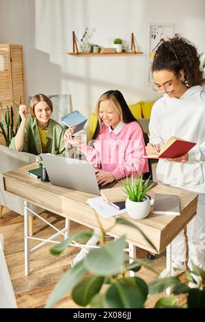 Un groupe diversifié d'adolescentes se sont rassemblées autour d'un ordinateur portable, engagées dans l'étude et la promotion de l'amitié dans le confort de la maison. Banque D'Images