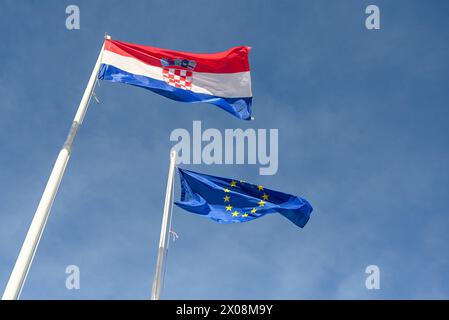 Drapeau croate et UE agitant au vent. Drapeaux de la Croatie et de l'Union européenne flottant sur un poteau. Banque D'Images