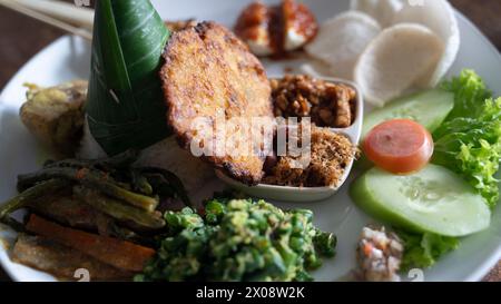 Traditionnel balinais Nasi Campur avec plusieurs plats sur plaque blanche Banque D'Images