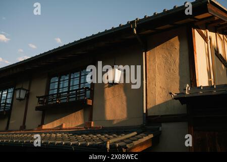 Architecture japonaise traditionnelle baignée de lumière chaude du coucher du soleil, représentant la sérénité et le patrimoine culturel Banque D'Images