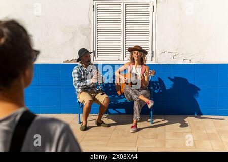 Un duo de musique se produit dans la rue, avec un clarinettiste et un guitariste jouissant de leur compris Banque D'Images