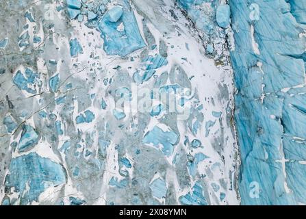 Une superbe photo aérienne capturant les motifs complexes et les teintes bleu foncé des crevasses sur un glacier islandais, mettant en valeur la beauté naturelle et les géologues Banque D'Images