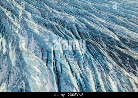Cette superbe prise de vue aérienne capture les détails complexes de la surface d'un glacier en Islande, mettant en évidence les motifs et textures naturels de la glace Banque D'Images