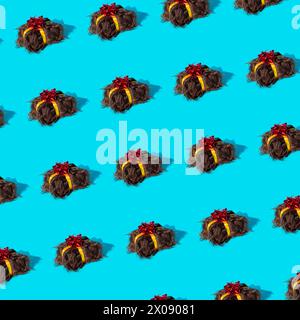 Motif sans couture de perruques orné de rubans rouges et jaunes sur un fond bleu vif, évoquant une ambiance festive. Banque D'Images