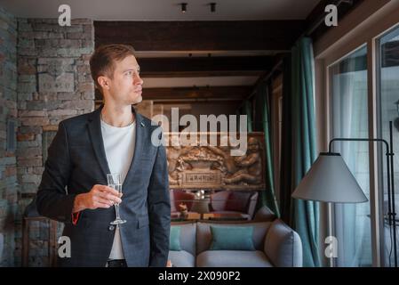 Scène d'hôtel de luxe avec homme en costume sombre tenant du verre, Zermatt, Suisse Banque D'Images