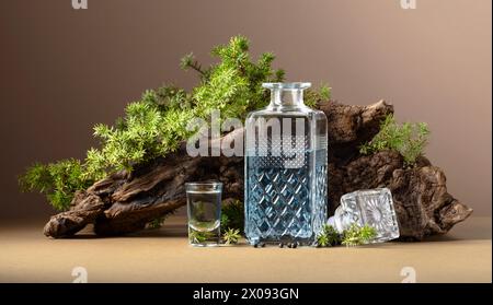 Gin bleu en carafe sur un fond de vieux accrocs et de branches de genévrier avec des baies. Fond beige avec espace de copie. Banque D'Images