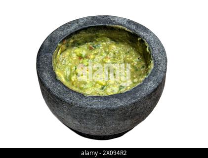 guacamole à l'intérieur molcajete (mortier mexicain traditionnel et pilon pour moudre les épices) trempette d'avocat isolé sur fond blanc, découpé Banque D'Images