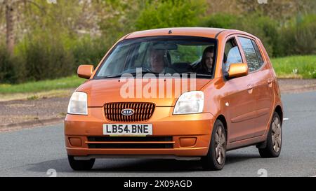 Milton Keynes, UK- 8 avril 2024 : 2004 orange Kia Picanto voiture conduite sur une route britannique Banque D'Images