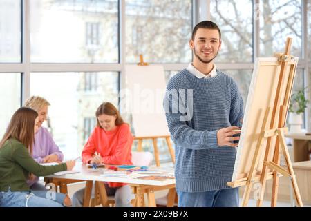 Étudiant masculin peinture sur toile à l'école d'art. Banque D'Images