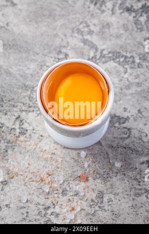 Oeuf cru dans un coquetier sur la table de la cuisine Banque D'Images