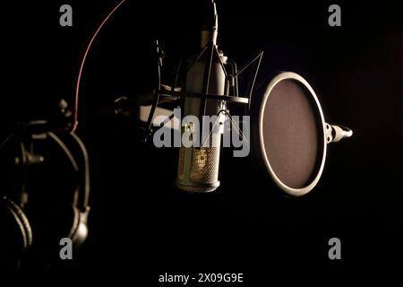 Un ensemble de microphone, filtre pop et casque pour les chanteurs lors de l'enregistrement de chansons dans un studio d'enregistrement de musique. Banque D'Images