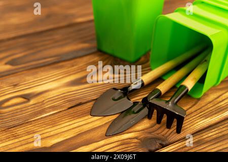 Une collection d'outils de jardinage miniatures sur une table en bois, y compris des pelles, des râteaux et des pots pour les semis Banque D'Images