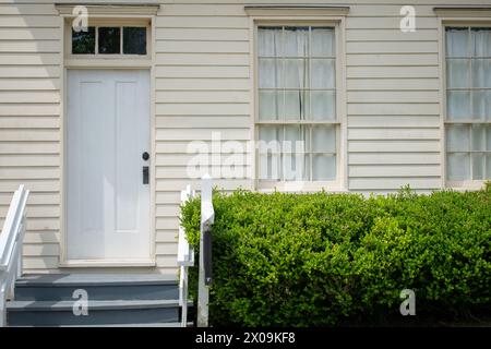 Charmante entrée à la vieille maison avec buisson vert et vieille fenêtre Banque D'Images