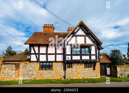 Vue sur la rue d'une grande maison à colombages roses haut de gamme à Bix, un joli village de campagne pittoresque près de Henley-on-Thames, dans le sud de l'Oxfordshire Banque D'Images