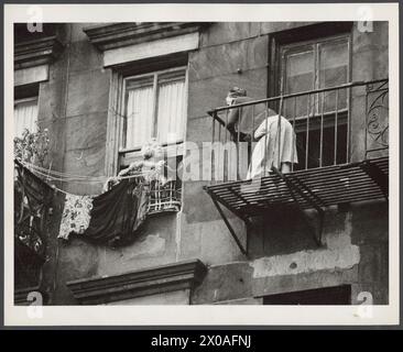 Deux femmes discutant l'une avec l'autre depuis l'étage supérieur d'un immeuble ; femme à gauche épingle la lessive à linge, l'une à droite se tient sur Firescape, New York, New York, septembre 1955. (Photo Anthony Rizzuto/Anthony Angel Collection) Banque D'Images