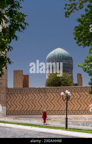 27 JUIN 2023, BOUKHARA, OUZBÉKISTAN : la vue d'une dame marchant devant la mosquée Bibi Khanym à Samarqand, Ouzbékistan Banque D'Images