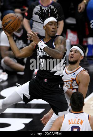 Los Angeles, États-Unis. 10 avril 2024. Le garde des Clippers de Los Angeles Terance Mann (14 ans) passe la balle loin du garde des Suns de Phoenix Devin Booker (R) lors de la première mi-temps au Crypto.com Arena de Los Angeles le mercredi 10 avril 2024. Photo par Alex Gallardo/UPI crédit : UPI/Alamy Live News Banque D'Images