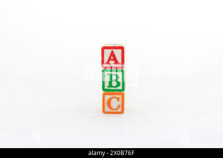 Blocs d'alphabet en bois orthographiant ABC isolé sur un fond blanc avec espace de copie. Banque D'Images