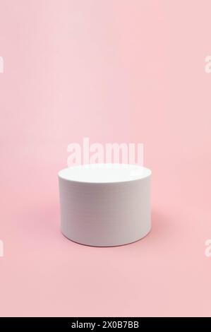 Podium rond blanc sur fond rose. Forme abstraite géométrique pour la présentation de produits cosmétiques. Copier l'espace. Banque D'Images