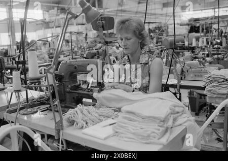 Aktuell 28-6-1973 : Trebarnsmamma på fabrikkgolvetKvinnenes kår i arbeidslivet Jofrid Jensen jobber på trikotasjefabrikken Harald Christensen A/S. I dag har fabrikken en arbeidsstokk på 70 personer, av dem 65 kvinner. Alle jobber akkord. Hun er fornøyd Med lønnen. Timelønnen til de ansatte kan på det mest ekstreme variere mellom 9 og 17 kroner timen, men det pleier ikke å ta lang tid før kvinnene arbeider i et raskt akkordtempo. Foto : ODD Ween / Aktuell / NTB ***FOTO IKKE BILDEBEHANDLET*** ce texte a été traduit automatiquement! Banque D'Images