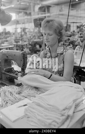 Aktuell 28-6-1973 : Trebarnsmamma på fabrikkgolvetKvinnenes kår i arbeidslivet Jofrid Jensen jobber på trikotasjefabrikken Harald Christensen A/S. I dag har fabrikken en arbeidsstokk på 70 personer, av dem 65 kvinner. Alle jobber akkord. Hun er fornøyd Med lønnen. Timelønnen til de ansatte kan på det mest ekstreme variere mellom 9 og 17 kroner timen, men det pleier ikke å ta lang tid før kvinnene arbeider i et raskt akkordtempo. Foto : ODD Ween / Aktuell / NTB ***FOTO IKKE BILDEBEHANDLET*** ce texte a été traduit automatiquement! Banque D'Images
