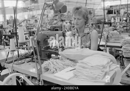 Aktuell 28-6-1973 : Trebarnsmamma på fabrikkgolvetKvinnenes kår i arbeidslivet Jofrid Jensen jobber på trikotasjefabrikken Harald Christensen A/S. I dag har fabrikken en arbeidsstokk på 70 personer, av dem 65 kvinner. Alle jobber akkord. Hun er fornøyd Med lønnen. Timelønnen til de ansatte kan på det mest ekstreme variere mellom 9 og 17 kroner timen, men det pleier ikke å ta lang tid før kvinnene arbeider i et raskt akkordtempo. Foto : ODD Ween / Aktuell / NTB ***FOTO IKKE BILDEBEHANDLET*** ce texte a été traduit automatiquement! Banque D'Images