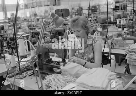 Aktuell 28-6-1973 : Trebarnsmamma på fabrikkgolvetKvinnenes kår i arbeidslivet Jofrid Jensen jobber på trikotasjefabrikken Harald Christensen A/S. I dag har fabrikken en arbeidsstokk på 70 personer, av dem 65 kvinner. Alle jobber akkord. Hun er fornøyd Med lønnen. Timelønnen til de ansatte kan på det mest ekstreme variere mellom 9 og 17 kroner timen, men det pleier ikke å ta lang tid før kvinnene arbeider i et raskt akkordtempo. Foto : ODD Ween / Aktuell / NTB ***FOTO IKKE BILDEBEHANDLET*** ce texte a été traduit automatiquement! Banque D'Images