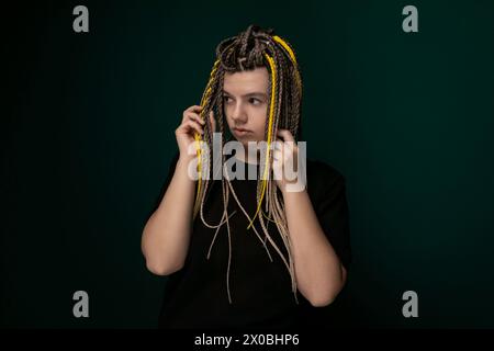 Femme avec des dreadlocks tenant les cheveux devant le visage Banque D'Images