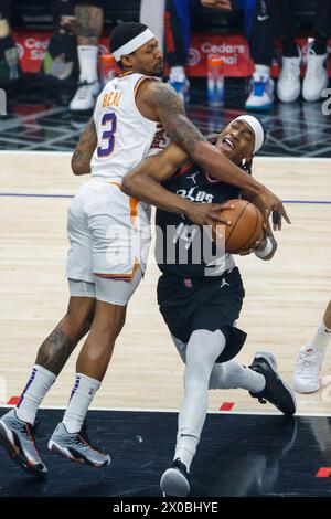 Los Angeles, États-Unis. 10 avril 2024. Terance Mann (R) des Los Angeles Clippers monte dans le panier contre Bradley Deal des Phoenix Suns lors du match de saison régulière NBA 2023-2024 entre les Los Angeles Clippers et les Phoenix Suns à Los Angeles, États-Unis, le 10 avril 2024. Crédit : Ringo Chiu/Xinhua/Alamy Live News Banque D'Images
