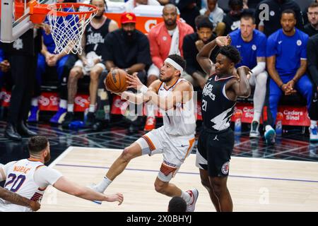 Los Angeles, États-Unis. 10 avril 2024. Devin Booker (C) de Phoenix Suns monte dans le panier lors du match de saison régulière NBA 2023-2024 entre les Clippers de Los Angeles et les Suns de Phoenix à Los Angeles, aux États-Unis, le 10 avril 2024. Crédit : Ringo Chiu/Xinhua/Alamy Live News Banque D'Images