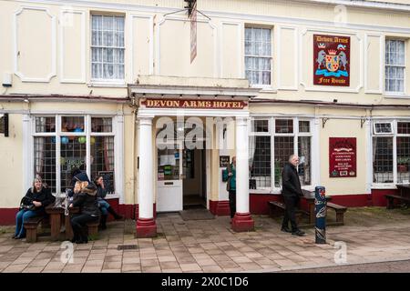 Des gens assis devant la maison publique Devon Arms à Teignmouth, Devon, Royaume-Uni. Photographie couleur. Banque D'Images