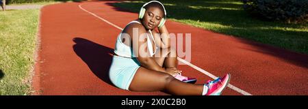 Femme afro-américaine en vêtements de sport, assise en toute confiance sur le court Banque D'Images