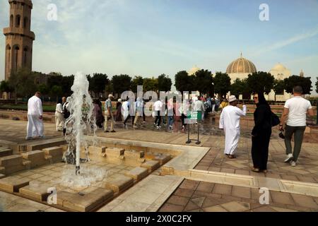 Sultan Qaboos Grand Mosquée visiteurs marchant près de la fontaine Muscat Oman Banque D'Images